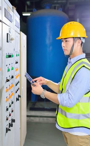 Side view of one industry engineer working at electricity control panel.